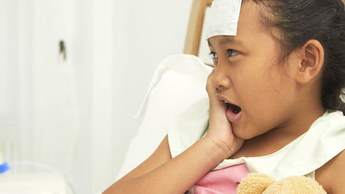 Close-up of girl with toothache in hospital