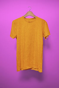 High angle view of clothes hanging on pink background