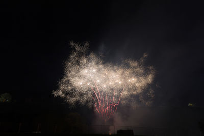 Low angle view of firework display at night