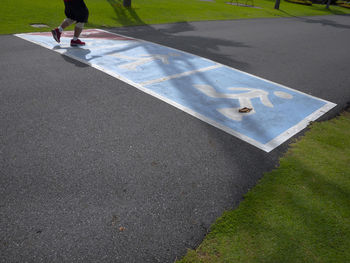 Low section of man walking on road sign