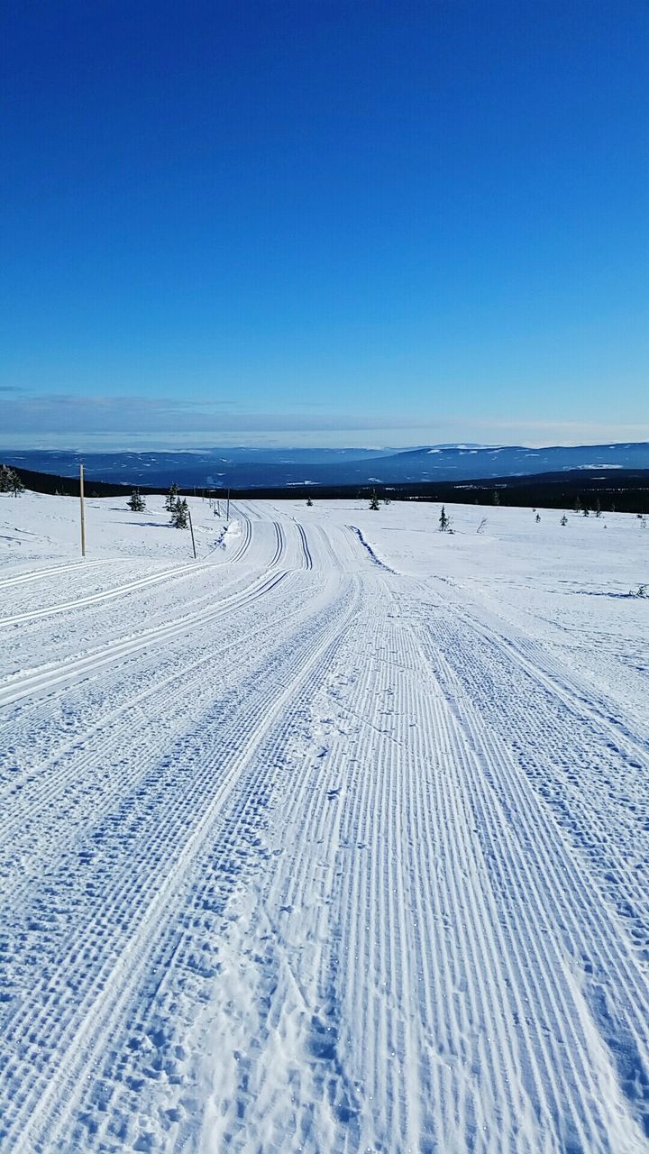 clear sky, copy space, snow, winter, blue, cold temperature, tranquil scene, tranquility, landscape, nature, scenics, beauty in nature, tire track, sand, beach, outdoors, season, day, covering, non-urban scene