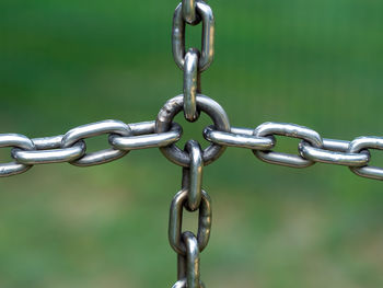 Close-up of chain hanging on metal fence