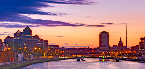 Illuminated buildings against sky during sunset