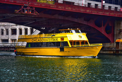 Yellow bridge over river in city