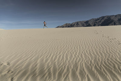 A man runs in the desert sand in death valley