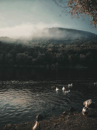 View of lake by mountains against sky