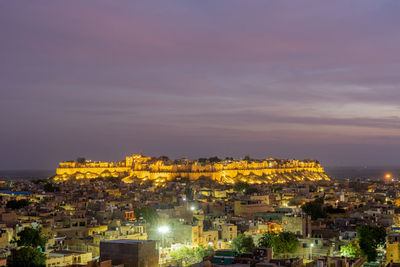 High angle view of illuminated buildings against sky at sunset