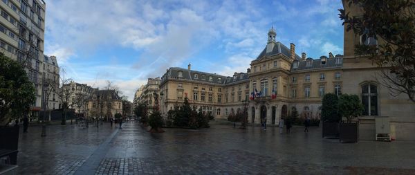 Panoramic view of city street and buildings against sky