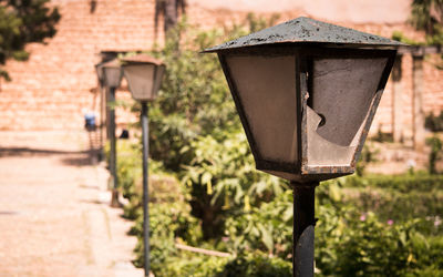 Close-up of electric lamp on street by building