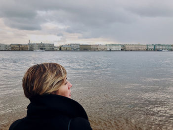Rear view of man looking at sea against sky