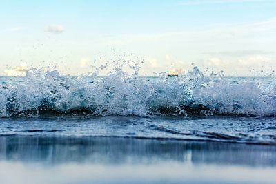 Close-up of wave on beach against sky