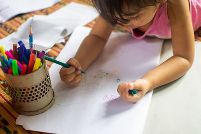 High angle view of girl wearing mask on table