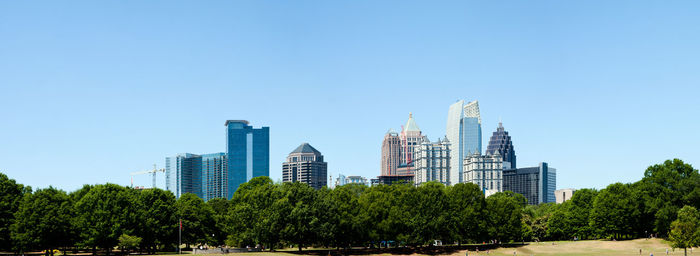 Low angle view of skyscrapers against clear blue sky