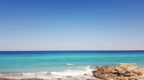 Scenic view of sea against clear blue sky