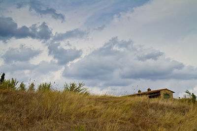 Panoramic view of cottage on field against sky