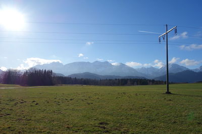 Scenic view of electricity pylon on field against sky