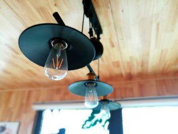 Low angle view of light bulb hanging at home