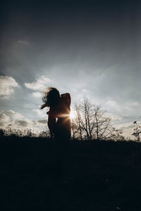 Rear view of woman standing against sky