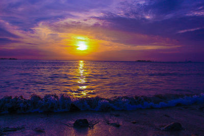 Scenic view of sea against dramatic sky during sunset