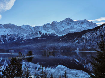 Scenic view of lake and snowcapped mountains against sky