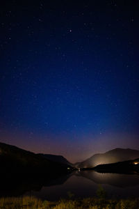 Scenic view of lake against sky at night