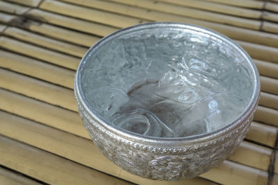Drinking water and ice cube in metal bowl, thai traditional container