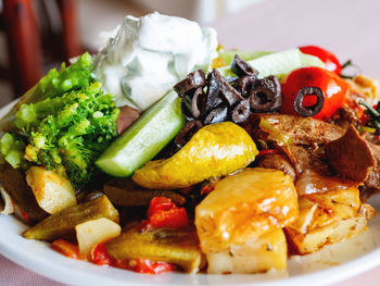 Healthy dinner - plate full of stewed vegetables, rice and meat with natural yogurt.