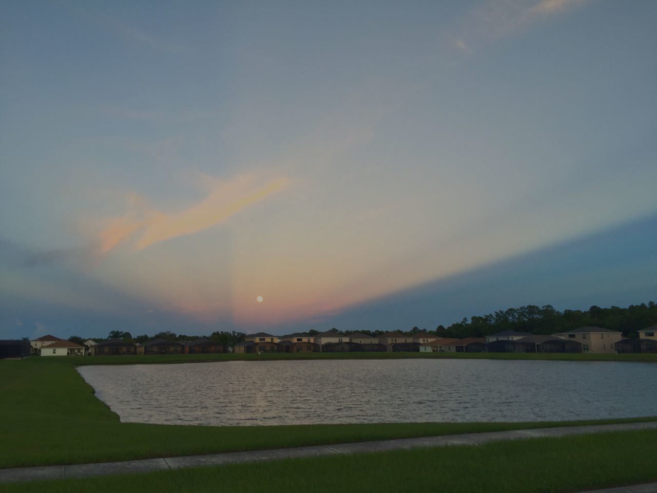 water, tranquil scene, dusk, lake, scenics, sky, tranquility, travel destinations, cloud - sky, tourism, beauty in nature, vacations, sunbeam, nature, canal, dramatic sky, majestic, multi colored, outdoors, atmosphere, urban skyline, back lit, non-urban scene, dawn, sun, no people