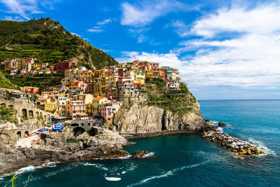 Scenic view of sea by buildings against sky