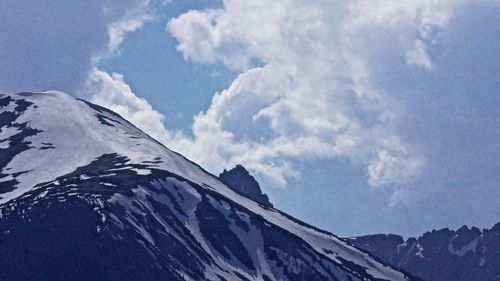 Low angle view of snowcapped mountains against sky