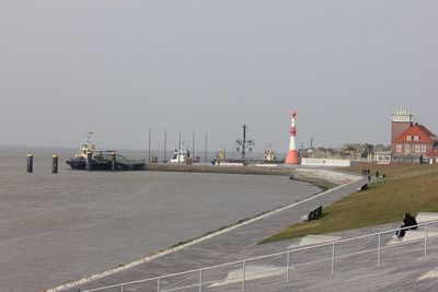 Scenic view of sea by buildings against clear sky