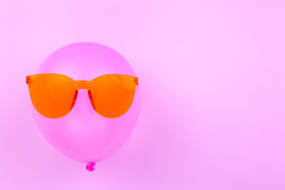 Close-up of heart shape with pink balloons against gray background