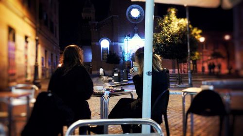 Woman in illuminated city at night