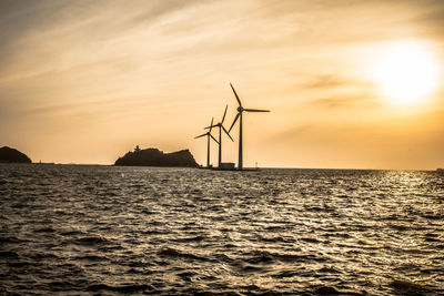 Silhouette of wind turbines at sunset