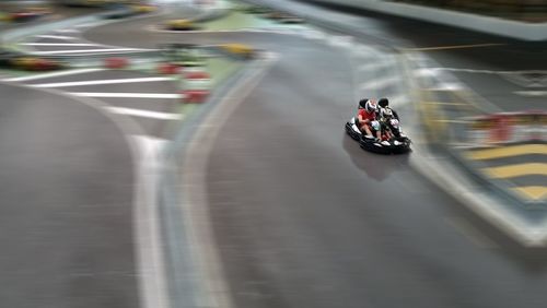 Blurred motion of man riding car on road in city