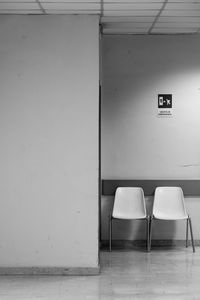 Empty chairs against wall in building