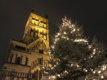 Low angle view of illuminated christmas tree against sky at night