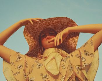 Portrait of beautiful woman wearing hat against sky