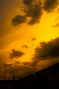Low angle view of silhouette buildings against dramatic sky