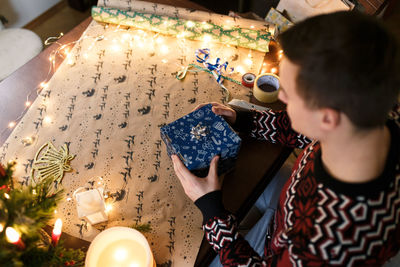 Young man packs christmas presents for friends and family