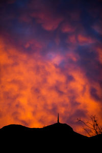 Low angle view of silhouette mountain against dramatic sky