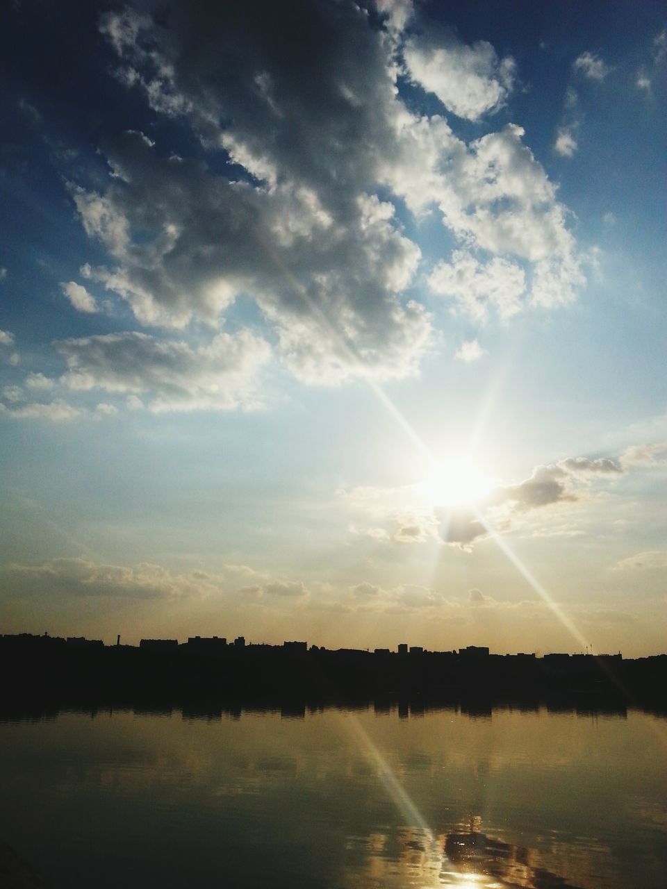 water, reflection, sun, tranquil scene, tranquility, scenics, beauty in nature, lake, waterfront, sky, sunset, sunlight, sunbeam, nature, idyllic, river, cloud - sky, cloud, outdoors, silhouette