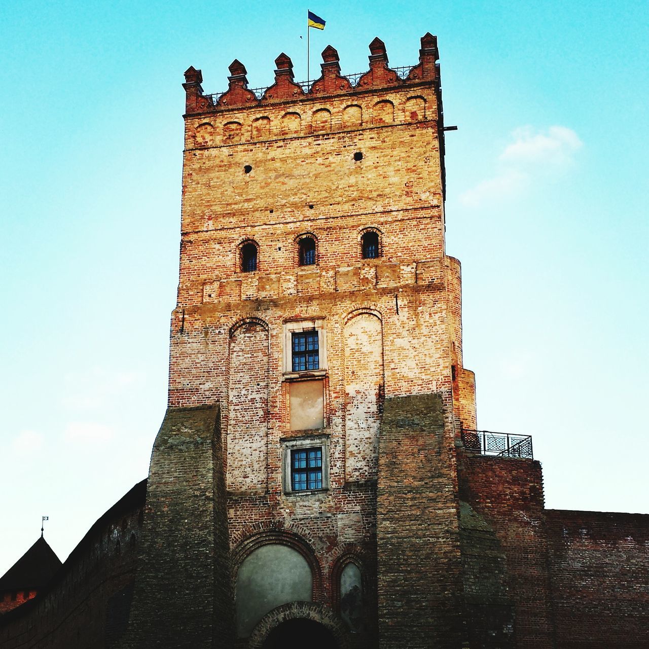 architecture, built structure, building exterior, low angle view, history, blue, sky, clear sky, old, tower, the past, day, stone wall, sunlight, outdoors, brick wall, no people, building, window, travel destinations