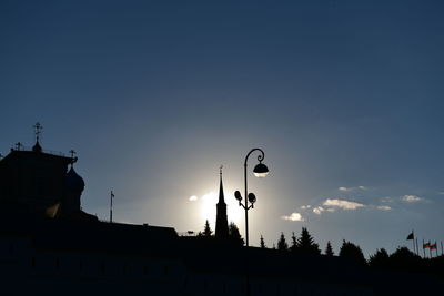 Low angle view of silhouette street light and building against sky