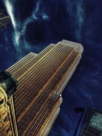 Low angle view of modern building against cloudy sky