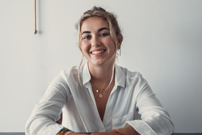 Portrait of young woman sitting on table