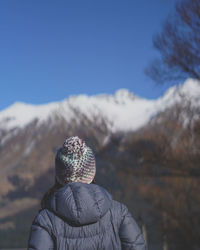 Rear view of man looking at mountain against sky