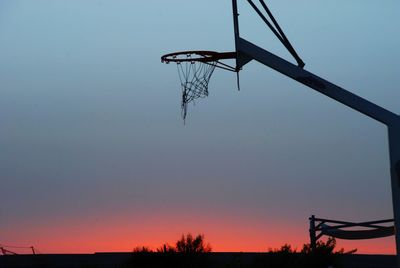 Low angle view of basketball hoop against sky during sunset