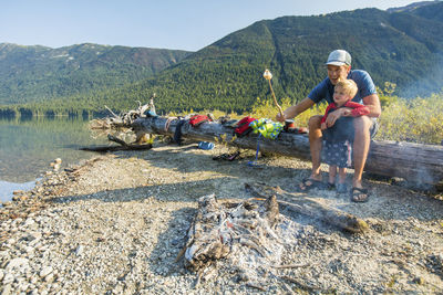 Father and son roast marshmallows over fire during a father son trip