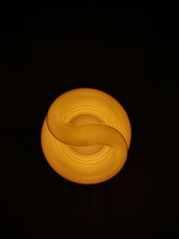 Close-up of yellow light bulb against black background